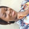 A clear headshot of a dark skin smiling woman 